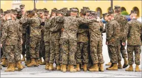  ??  ?? On Sept. 11, the Marine Corps’ newest Marines hug and congratula­te one another on the parade deck after their graduation ceremony. No visitors were allowed.