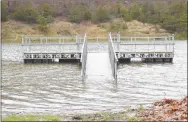  ?? Westside Eagle Observer/MIKE ECKELS ?? The fishing dock at Crystal Lake near Decatur turned into a small island after 6-10 inches of rain fell March 19, causing lake levels to rise four inches or more.