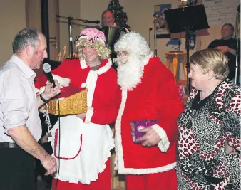  ??  ?? Long serving MC, Michael Lyons Sr. chatting with Santa and Mrs Claus at the 2013 senior citizens’ party in Araglin. On the right is the late, Mary Fitzgerald, who was the mainstay of the party for so many years. (Pic: John Ahern)