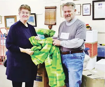  ??  ?? Debbie Brown of Longwarry District Foodbank receiving a warm blanket from Drouin Rotary Club president Tim Wills.