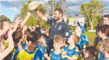  ??  ?? Blues player Wade Graham puts a smile on the kids’ faces.