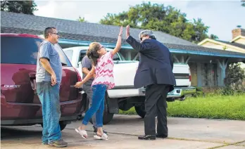  ?? Marie D. De Jesús photos / Houston Chronicle ?? Attorney David Medina congratula­tes Kimberly Rodriguez, 10, and her father, Juan Rodriguez.