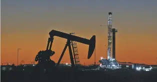  ?? JACOB FORD/ODESSA AMERICAN FILE PHOTO VIA AP ?? An oil rig and pump jack operate in October along a roadside in Midland, Texas. With more barrels of oil being pumped monthly from the Permian Basin, New Mexico is among the nation’s top producing states.