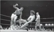  ?? THE ASSOCIATED PRESS FILE PHOTO ?? Antonio Inoki kicks Muhammad Ali to pull him down on the canvas during their World Martial Arts Championsh­ip fight in Tokyo in 1976. The fight ended in a draw.