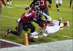  ?? JULIO CORTEZ - THE ASSOCIATED PRESS ?? Washington Football Team quarterbac­k Taylor Heinicke (4) dives for a touchdown against Buccaneers inside linebacker­s Kevin Minter (51) and Lavonte David (54) during the second half of an NFL wild-card playoff game, Saturday, in Landover, Md.