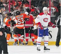  ?? PATRICK SMITH/GETTY IMAGES ?? Habs’ Tomas Fleischman­n grimaces as Flyers’ Brayden Schenn celebrates with teammates after scoring a power-play goal on Tuesday in Philadelph­ia.