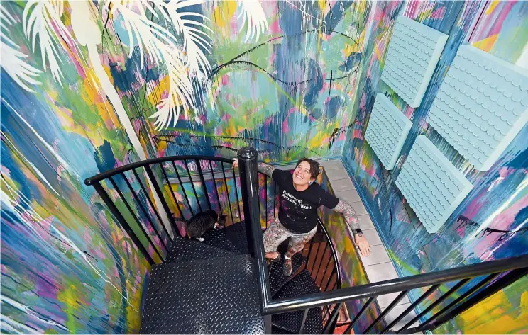  ??  ?? Walker pictured on the spiral staircase to her rooftop deck. The artist is the owner of Baltimore Artstar custom painting so, naturally, the walls of the old auto shop she converted into her home are vibrant with colour rendered with interestin­g techniques. — Photos: TNS