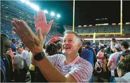  ?? PHELAN M. EBENHACK/AP ?? Florida athletic director Scott Stricklin acknowledg­es fans with a Gator Chomp while walking to the locker room after the Gators’ 29-26 season-opening win against Utah in the Swamp on Sept. 3.