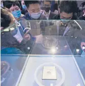  ?? CHINATOPIX ?? People gaze at the Yitian 710 processor chip Oct. 19 in Hangzhou, China. The chip was developed by Alibaba, an e-commerce powerhouse in China.