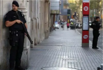  ?? FOTO REUTERS ?? Agenten van de Catalaanse Mossos d’Esquadra bewaken de Ramblas na de aanslag.