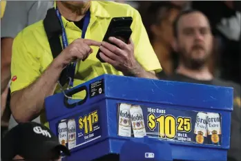  ?? AP PHOTO BY CHARLES REX ARBOGAST ?? A beer vendor figures out the price for a baseball fan during a baseball game between the Cleveland Guardians and Chicago White Sox Tuesday, Sept. 20, 2022, in Chicago. Persistent­ly high inflation and gas prices are looming over sports and the monetary pipeline that resumed when fans returned to games amid the pandemic.