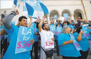  ?? Al Seib Los Angeles Times ?? UBER DRIVER Joel Carbonell, left, and Lyft driver Eduardo Belacazar, center, are among demonstrat­ors rallying outside City Hall in support of a proposed $30-an-hour guarantee for ride-hailing drivers in L.A.