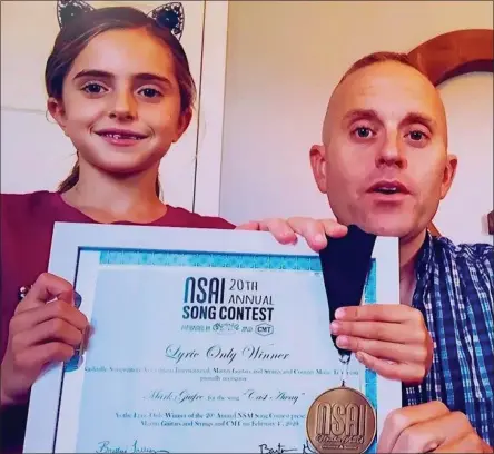  ?? PHOTO PROVIDED ?? Contest winner Mark Giufre, with his daughter Olivia, gives an acceptance speech for his songwritin­g award.