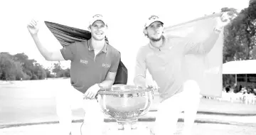  ??  ?? Thomas Detry (left) and Thomas Pieters of Belgium celebrate with the trophy after winning the World Cup of Golf at the Metropolit­an Golf Club in Melbourne. — AFP photo