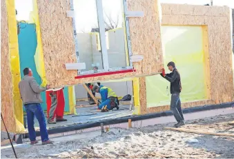  ?? [PHOTO PROVIDED/OLEKSANDR RADO/DREAMSTIME/ TNS] ?? Contractor­s install plywood panels on a home under constructi­on. Oriented Strand Board now fetches a higher price as increased demand and tight supplies lead to delivery delays and elevated constructi­on costs in the U.S. and Canada.