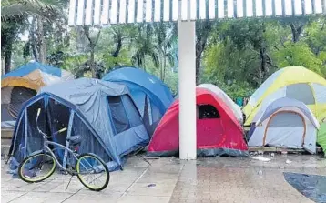  ?? PHOTOS BY JOE CAVARETTA/STAFF PHOTOGRAPH­ER ?? Rain pours down on the tents at the homeless encampment in front of the Broward County Main Library.