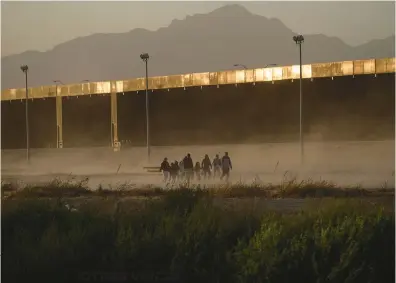  ?? GUILLERMO ARIAS/GETTY-AFP ?? OTHER VOICES
Migrants walk to surrender to the U.S. Border Patrol, seen from Ciudad Juarez, Mexico, on March 30.