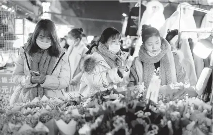  ?? GETTY ?? Chinese authoritie­s have pushed conspiracy theories that COVID-19 originated anywhere but Wuhan, China. Above, shoppers at a market in Wuhan.