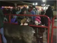  ?? ZACHARY SRNIS — THE MORNING JOURNAL ?? Mike Owens of Lorain, left, is with nephew Ryan Bailey, 4, of Lorain, and niece Emma Owens, right, 6, of Lorain as they pet reindeer during Waterfront Winterfest in downtown Lorain.