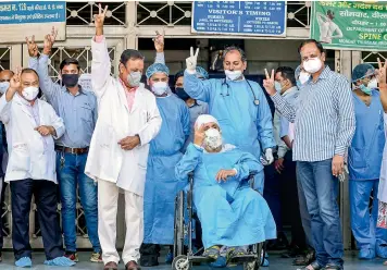  ?? — PTI ?? Eighty-two-year-old Manmohan Singh, in a wheelchair, comes out from the Lok Nayak Jai Prakash Narayan (LJNP) Hospital in New Delhi on Tueday amid cheers from doctors and medical staff after he fully recovered from Covid-19. The elderly are among the most vulnerable groups.