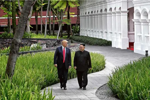  ?? Kevin Lim/The Straits Times/Reuters ?? O presidente dos EUA, Donald Trump, e o ditador Kim Jong-un caminham pelo hotel onde ocorreu o encontro em Singapura