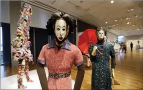  ?? ELAINE THOMPSON — THE ASSOCIATED PRESS ?? Nigerian masks from the 1950s are displayed with costumes to create a “masquerade parade” as part of the show “Disguise: Masks & Global African Art” at the Seattle Art Museum on Sunday. Race, identity and the masks people wear are the themes explored...