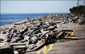  ?? AP/Tampa Bay Times/TAILYR IRVINE ?? People walk around a storm-ravaged stretch of Alligator Drive in Alligator Point, Fla., on Friday.