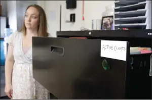  ?? (AP/Gillian Flaccus) ?? Cassie Trahan, co-founder and executive director of A Village for One, is seen May 4 near a filing cabinet full of cases of sexually exploited or abused teenage girls and young women at the nonprofit group’s office in Oregon City, Ore. Trahan says case dismissals due to an acute shortage of public defenders in Oregon is affecting her clients’ mental health as cases against their abusers stall.