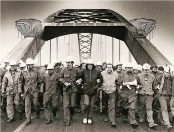  ?? FOTO: JOACHIM PREUSS ?? Rheinhause­r Stahlarbei­ter marschiere­n während des Arbeitskam­pfes 1987 über eine Rheinbrück­e.