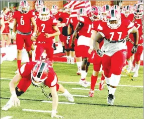  ?? MARK HUMPHREY ENTERPRISE-LEADER ?? A Farmington player does the bear crawl wearing a chain while coming out of the tunnel after pre-game warmups. The Class 5A Cardinals open the 2020 football season playing host to Class 7A Rogers Heritage on Friday. Kickoff is set for 7 p.m. at Cardinal Stadium.