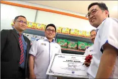  ??  ?? Chong signs a plaque to mark the launch of Unimas Students Food Bank, as (from left) Wan Hashim, Tan and Rostam look on.