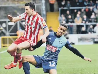  ??  ?? George Honeyman is sent flying at Adams Park.