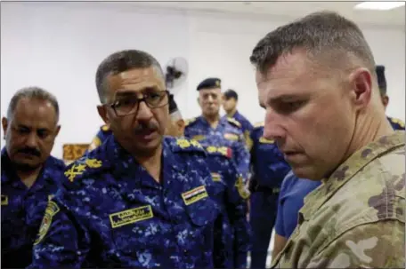  ?? BALINT SZLANKO — THE ASSOCIATED PRESS ?? Lt. Gen. Raid Shaker Jawlat, center, of the Iraqi federal police talks with Col. Pat Work of the U.S. Army’s 82nd Airborne Division as they look at a map of Mosul in Iraq on Friday. Work warned that troops in Mosul are at increased risk of friendly...