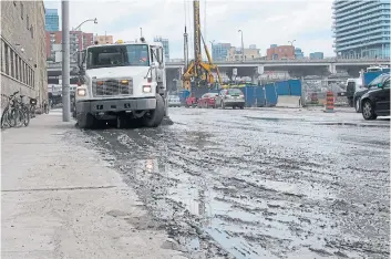  ?? JACK LAKEY PHOTO ?? With two condo constructi­on projects on Cooper St., which is only one block long, it was coated with mud last week after only a couple hours of rain. The mud was so heavy that a street sweeper used to clean it up managed only to smear it across the road.