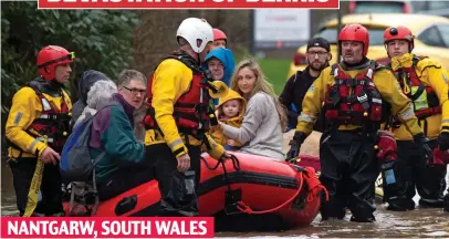  ??  ?? Floating to safety: A shell-shocked family are helped away from the scene of devastatio­n