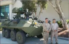  ?? ?? Cpl. Jenrich and Cpl. Matias stand by a “LAV-AT”