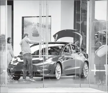  ?? Scott Olson Getty Images ?? TESLA plans to add an additional factory shift as it tries to ramp up Model 3 production to 6,000 a week by the end of June. The car is considered crucial to the automaker’s existence. Above, a showroom in Chicago.