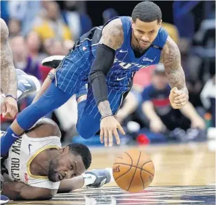  ?? SCOTT THRELKELD/ASSOCIATED PRESS ?? Magic G D. J. Augustin, right, dives for a loose ball over Pelicans G Tony Allen during the first half Monday in New Orleans. Augustin had 4 assists and 3 steals as Orlando bounced back from Sunday’s loss in Charlotte.