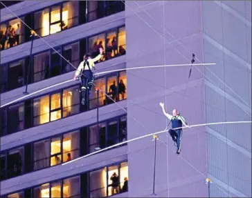  ?? EUGENE GOLOGURSKY/GETTY IMAGES NORTH AMERICA/AFP ?? Lijana Wallenda and Nik Wallenda walk a high wire over Times Square during the Highwire Live In Times Square with Nik Wallenda on Sunday in New York City.