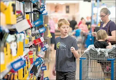  ?? NWA Democrat-Gazette/BEN GOFF ?? Andrew Kemp, 9, a fifth-grader at Janie Darr Elementary in Rogers, shops for school supplies this week with his mother, Holly Kemp, and sister Noelle, 2, at the Wal-Mart Supercente­r on Pleasant Crossing Boulevard in Rogers.