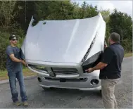  ??  ??  Donavan Harris and Lenny Reed easily remove the lightweigh­t fiberglass onepiece hood to reveal the high-power Cummins engine below.