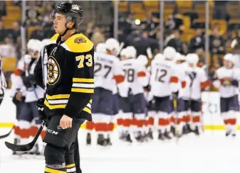  ?? Winslow Townson / Associated Press ?? As Florida players congratula­te each other, Boston’s Charlie McAvoy skates off the ice knowing the Bruins missed a chance to be the No. 1 seed in the Eastern Conference playoffs.