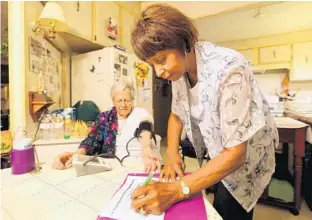  ?? RICARDO RAMIREZ BUXEDA/STAFF PHOTOGRAPH­ER ?? Rosaria Infantino, 88, left, gets her blood pressure checked during a home visit from Roenea Dixon-Dean as part of the Osceola County Council on Aging’s Care Companion program.