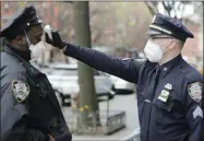  ?? FRANK FRANKLIN II—ASSOCIATED PRESS ?? Officer Mahoney, right, checks the temperatur­e of all people entering the 32nd precinct of the New York Police Department in an attempt to stem the spread of the new coronaviru­s Wednesday, April 15, 2020, in New York.