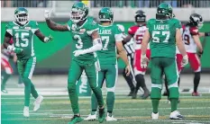  ?? BRANDON HARDER ?? The Saskatchew­an Roughrider­s’ Nick Marshall, middle, celebrates a 67-yard intercepti­on return for a touchdown during Sunday’s 40-27 victory over the visiting Calgary Stampeders.