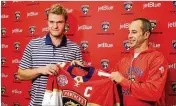  ?? EMILY MICHOT / MIAMI HERALD ?? Aleksander Barkov (left) of the Florida Panthers gets the captain’s jersey earlier this month from Derek MacKenzie, captain for the past two seasons.