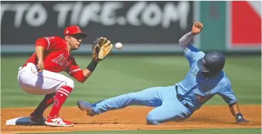  ?? JAYNE KAMIN-ONCEA / USA TODAY SPORTS ?? Angels third baseman David Fletcher takes the throw as Toronto’s Marcus Semien is
caught stealing in Game 1 of Tuesday’s doublehead­er, which Los Angeles won 6-3.