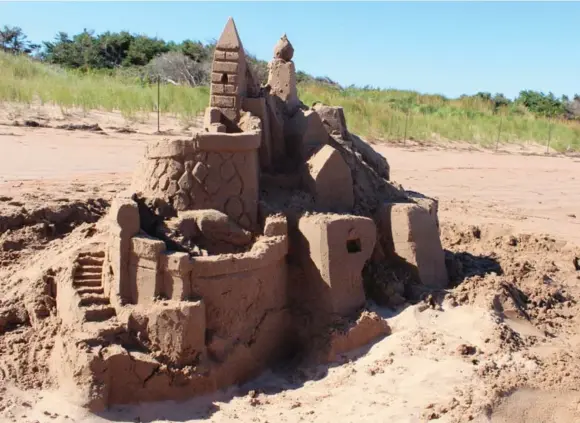  ?? JENNIFER BAIN PHOTOS/TORONTO STAR ?? Jennifer Bain helped Maurice Bernard, a sandcastle builder with Parks Canada, build a towering sculpture at Dalvay-by-the-Sea in Prince Edward Island National Park.