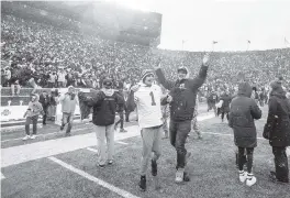  ?? TONY DING AP ?? Fans celebrate on the Michigan Stadium field in Ann Arbor after the Wolverines upset second-ranked Ohio State on Saturday afternoon.