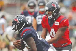  ?? Associated Press ?? n Houston Texans quarterbac­k Deshaun Watson (4) hands off to running back Dare Ogunbowale (44) during a joint practice with the New Orleans Saints on Thursday at the Saints NFL football training facility in Metairie, La.